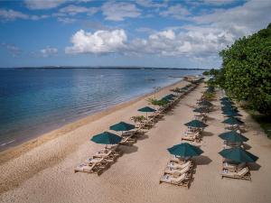 een uitzicht over een strand met stoelen en parasols bij Prama Sanur Beach Bali in Sanur