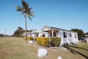 a house with a palm tree and a yard at BIG4 Breeze Holiday Parks - Bargara in Bargara