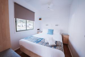 a bedroom with a white bed with a window at BIG4 Breeze Holiday Parks - Bargara in Bargara