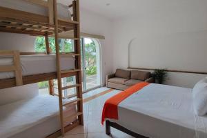 a bedroom with two bunk beds and a couch at Villa Martha Garza Blanca - Heated Pool, Chef & Full Staff Included in Puerto Vallarta +49 photos