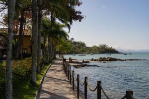 una pasarela junto a una playa con palmeras en Casa de Praia, en Porto Belo
