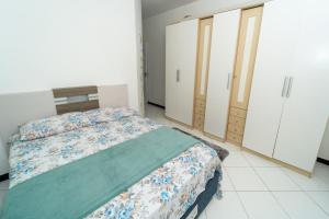 1 dormitorio con cama y armario en Casa de Praia, en Porto Belo