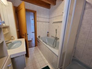 a bathroom with a tub and a sink at Ferienhaus Andrea AD0 in Blatten bei Naters +14 photos