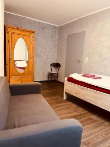 1 dormitorio con cama, silla y espejo en Vivi, en Wolfenbüttel