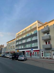 un edificio al lado de una calle con coches aparcados en Vivi, en Wolfenbüttel