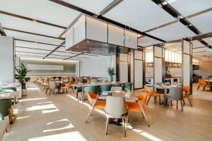 a restaurant with tables and chairs in a room at Shanxi Xiaohe Xincheng Talent Apartment in Taiyuan