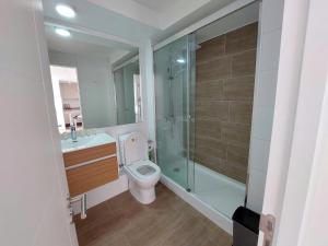 La salle de bains est pourvue de toilettes et d'une douche en verre. dans l'établissement Departamento con preciosa vista al mar y ciudad, à Puerto Montt