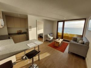a kitchen and living room with a view of the ocean at Departamento con preciosa vista al mar y ciudad in Puerto Montt