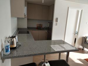 a kitchen with a granite counter top in a room at Departamento con preciosa vista al mar y ciudad in Puerto Montt