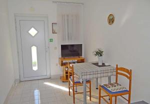 a dining room with a table and chairs and a television at Apartments Tomislav - 120 m from beach in Okrug Donji