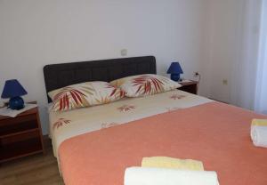 a bedroom with a bed with two lamps and two pillows at Apartments Tomislav - 120 m from beach in Okrug Donji