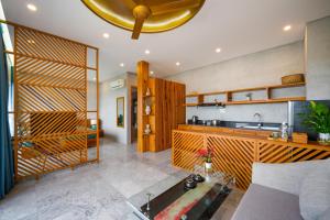 a kitchen with a sink and a living room at Bon Sand Villa & Spa Hoi An in Hoi An