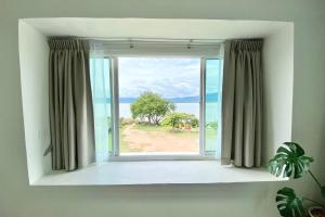 a window with a view of the ocean at PB Place @ Kwan Payao in Phayao