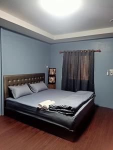 1 dormitorio con 1 cama grande y cabecero negro en เฮือนพรนาคา โฮมสเตย์, en Ban Don Klang