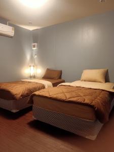Habitación con 2 camas en una habitación en เฮือนพรนาคา โฮมสเตย์, en Ban Don Klang
