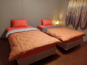 מיטה או מיטות בחדר ב-เฮือนพรนาคา โฮมสเตย์