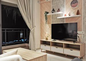 uma sala de estar com uma grande televisão de ecrã plano em Yussy Homestay at Regalia Park Forest City em Gelang Patah