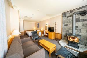 una sala de estar con chimenea en una habitación de hotel en Hotel Sierra Resort Hakuba, en Hakuba