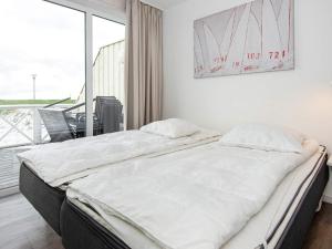 a large bed in a room with a large window at Two-Bedroom Holiday home in Wendtorf 34 in Wendtorf