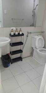 La salle de bains est pourvue de toilettes blanches et d'un lavabo. dans l'établissement Minimalist Studio Unit at Azure North San Fernando Pampanga, à San Fernando