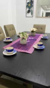 a black table with blue and white plates and flowers at Islamic Homestay Promenade Tanjung Lumpur in Kuantan