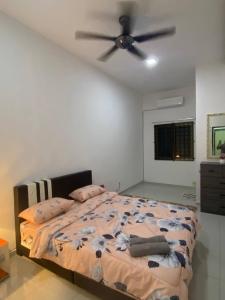 a bedroom with a bed with a ceiling fan at Islamic Homestay Promenade Tanjung Lumpur in Kuantan