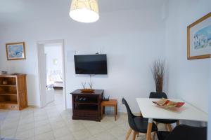 a living room with a table and a tv at Fira Central Apartments with Veranda in Fira