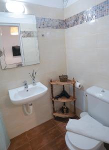 a bathroom with a sink and a toilet and a mirror at Fira Central Apartments with Veranda in Fira