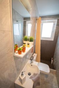uma casa de banho com um lavatório e um espelho em Meni Sweet Central Studio em Volos
