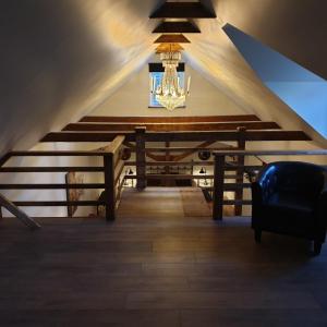 a room with a staircase with a chandelier and a chair at Gårdshus med spabad utomhus in Vadstena