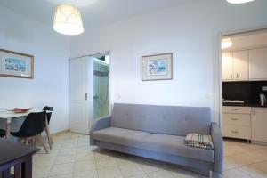 a living room with a couch and a table and a kitchen at Fira Central Apartments with Veranda in Fira