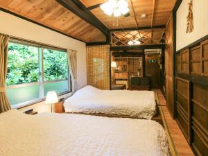 a bedroom with two beds and a window at #Nerome01 Traditional Okinawan House in Ogimi, bc in Ujimi