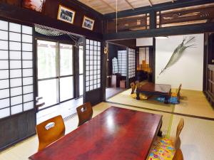 ein Esszimmer mit einem Holztisch und Stühlen in der Unterkunft Nerome#01 Okinawan Traditional House in YAMBARU,bc in Ujimi