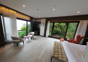 um quarto com uma cama grande, cadeiras e janelas em Şelale Otel em Rize