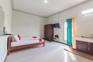 um quarto com uma cama e uma lareira num quarto em RedDoorz near GOR Sempaja Samarinda em Samarinda