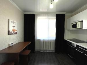 a kitchen with a table and a microwave and a window at 1-комнатная квартира, центр, супермаркет Сокол in Petropavlovsk