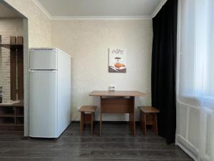 cocina con mesa y nevera blanca en 1-комнатная квартира, центр, супермаркет Сокол en Petropavlovsk