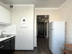 a kitchen with a white refrigerator and a sink at 1-комнатная квартира, центр, супермаркет Сокол in Petropavlovsk