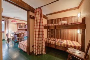 1 dormitorio con 2 literas y mesa en Grange Hike & Ski Sestriere Apartments - Happy.Rentals, en Sestriere
