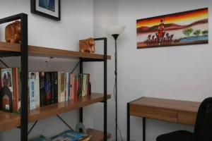 ein Wohnzimmer mit Bücherregal und Lampe in der Unterkunft Murlong - Hosted by Burleigh Letting in Gold Coast