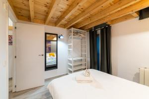 マドリードにあるLuxury Suite - Prime Locationの白いベッドと木製の天井が備わるベッドルーム1室が備わります。