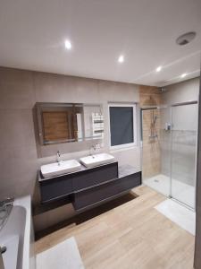 a bathroom with two sinks and a shower at Maison moderne et accueillante in Mackenheim