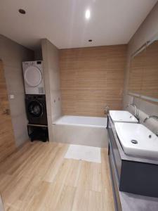 ein Badezimmer mit 2 Waschbecken und einer Waschmaschine in der Unterkunft Maison moderne et accueillante in Mackenheim