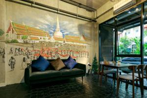 a living room with a couch and a painting on the wall at เดอะซิกเนเจอร์ นคร โฮเทล in Nakhon Si Thammarat