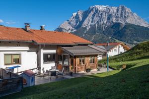 a house with a patio with a mountain in the background at Apart Leitner in Lermoos