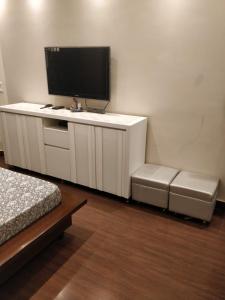 Cette chambre dispose d'une armoire avec une télévision et d'un lit. dans l'établissement DEER PARK LUXURY HOMESTAY (Safdarjang Enclave), à New Delhi