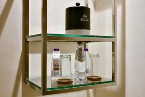 una estantería de cristal con botellas y vasos. en Golden Dune Hotel Turaif, en Turaif
