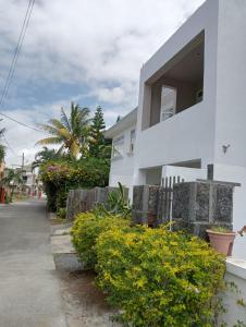 a white house with a window and some bushes at Chetty Tourist Residence in Pereybere