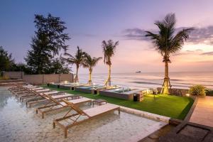 a resort with a pool and palm trees and the ocean at Carapace Residents Huahin-Khaotao in Khao Tao