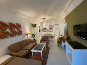 a living room with a couch and a table at Seaview Deluxe@Rainbow Paradise Tg Bungah 4-6pax in Tanjung Bungah